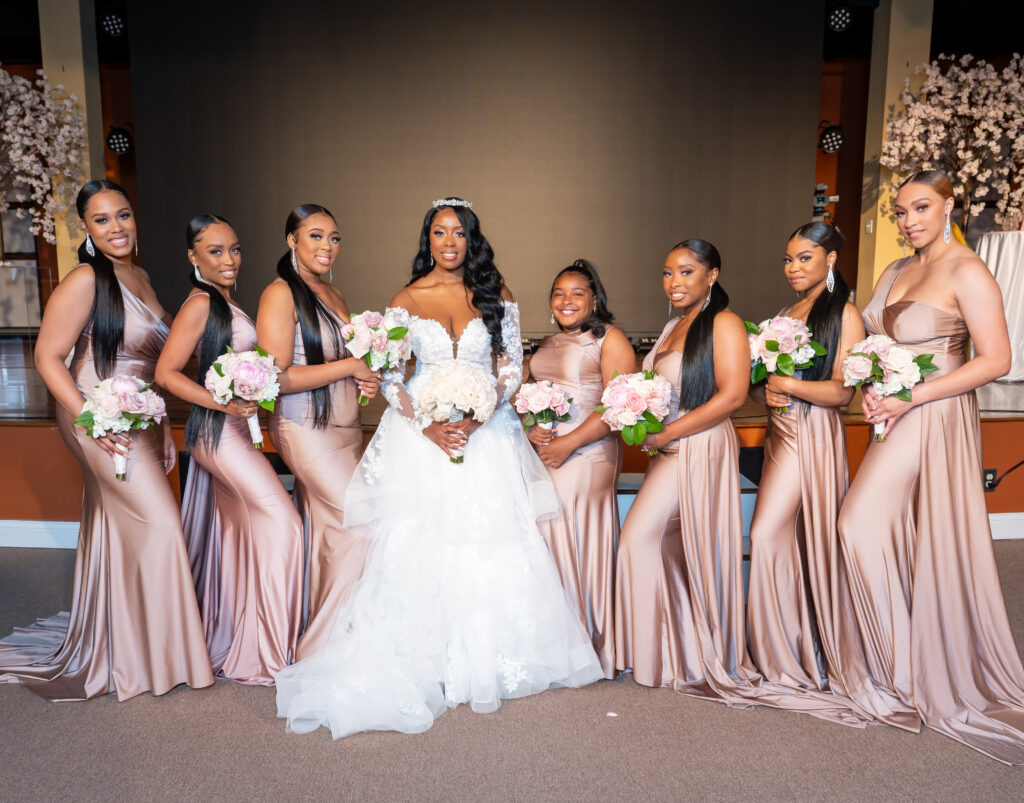 bride posing with bridesmaids at the ceremony 